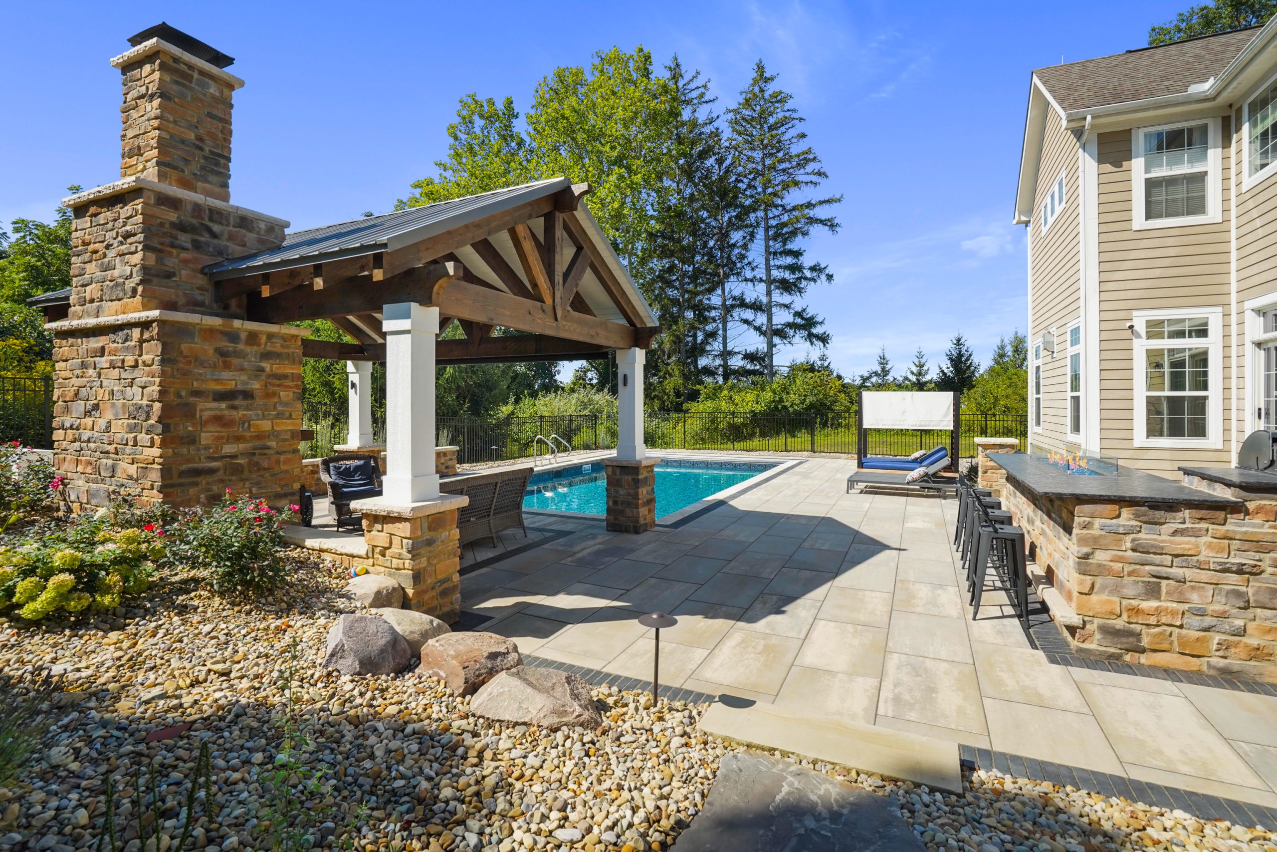 Pool within fenced backyard with trees outside the fence