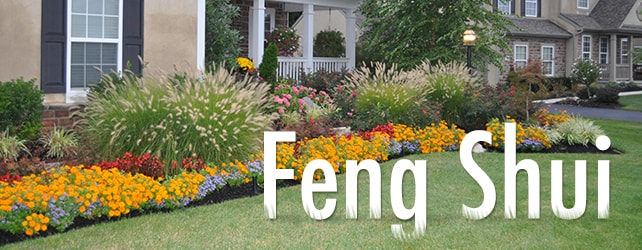 Image of a front yard with a vibrant flowerbed with the words "Feng Shui" placed into the image to look like the text is sitting on the grass