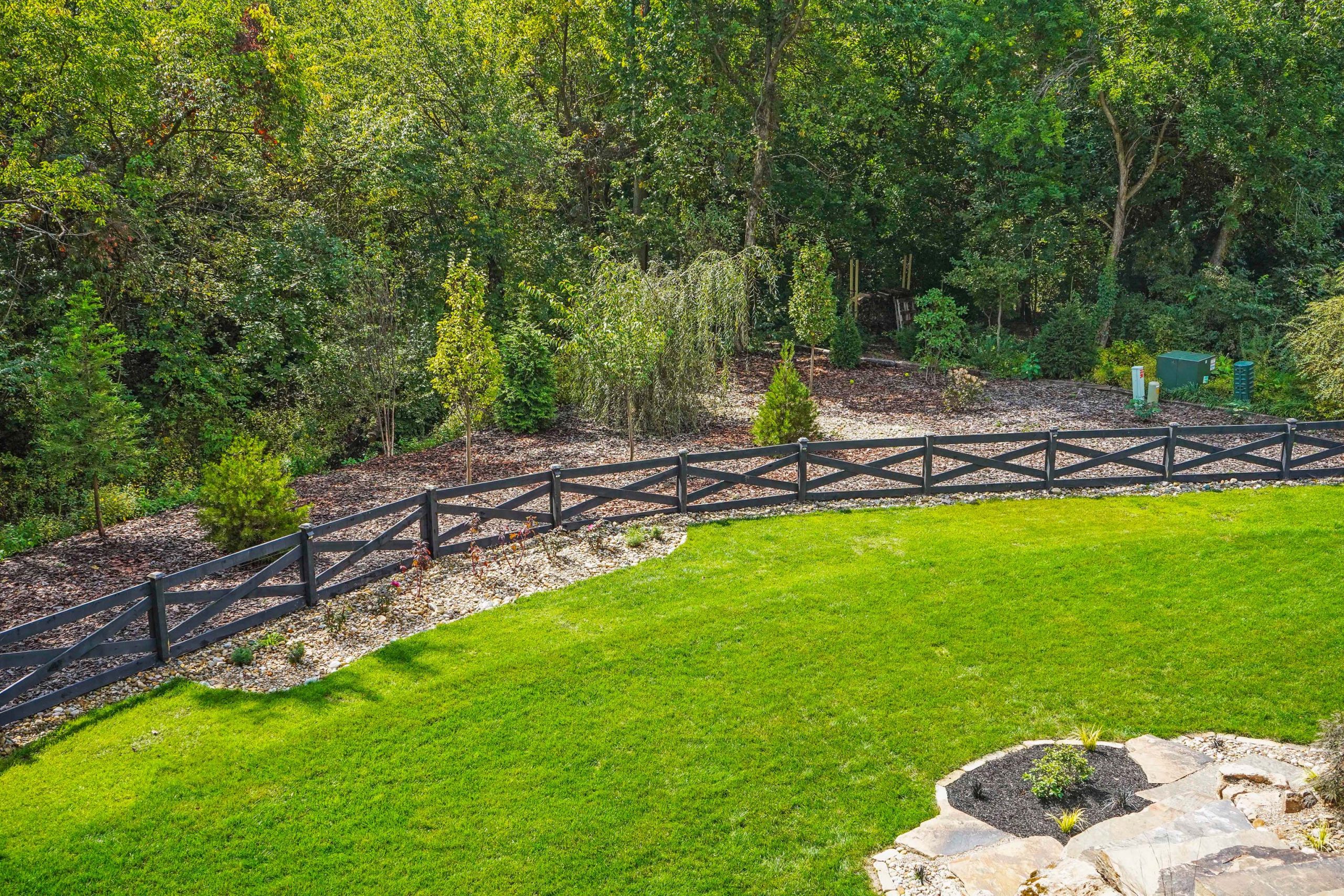 Lawn within fence and trees outside fence