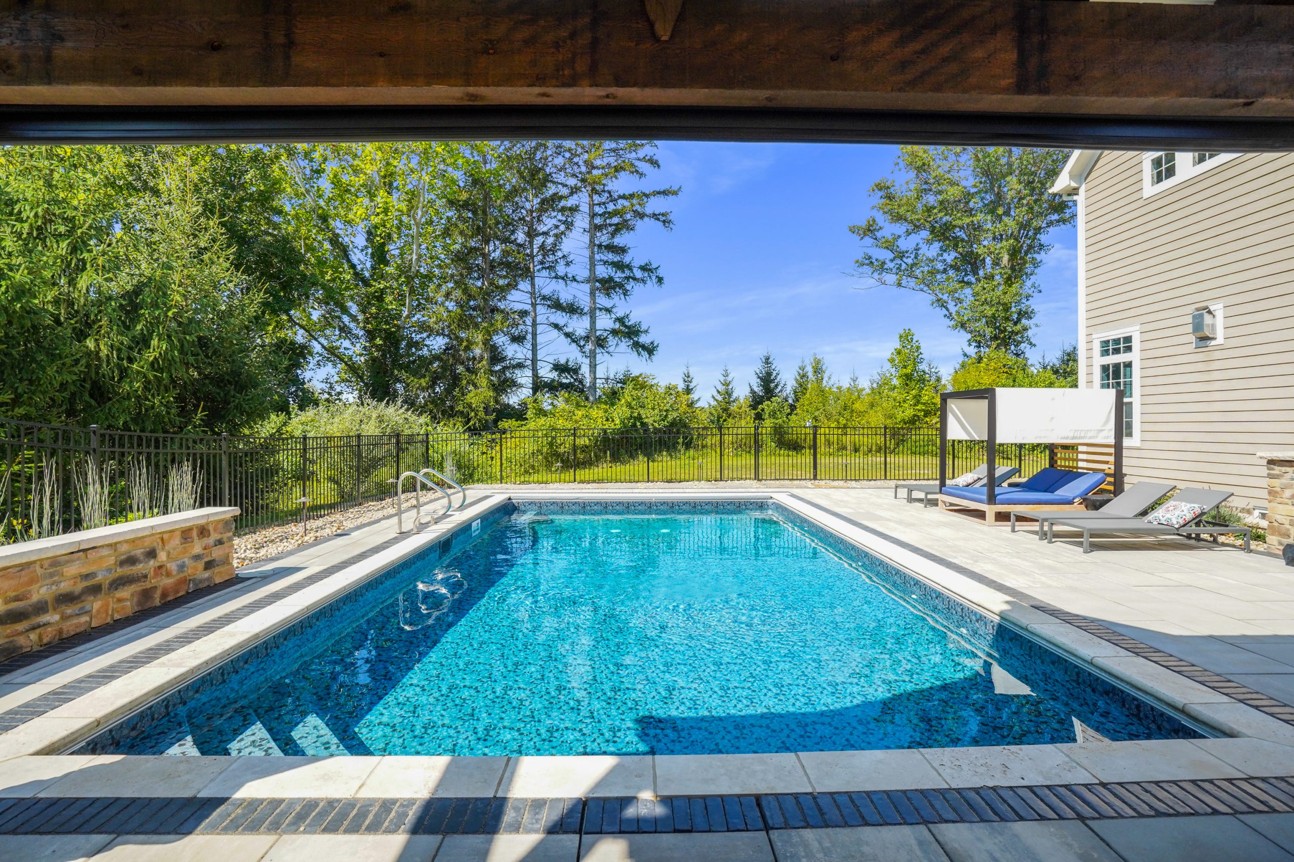 Pool chairs within fenced area and trees outside fenced area