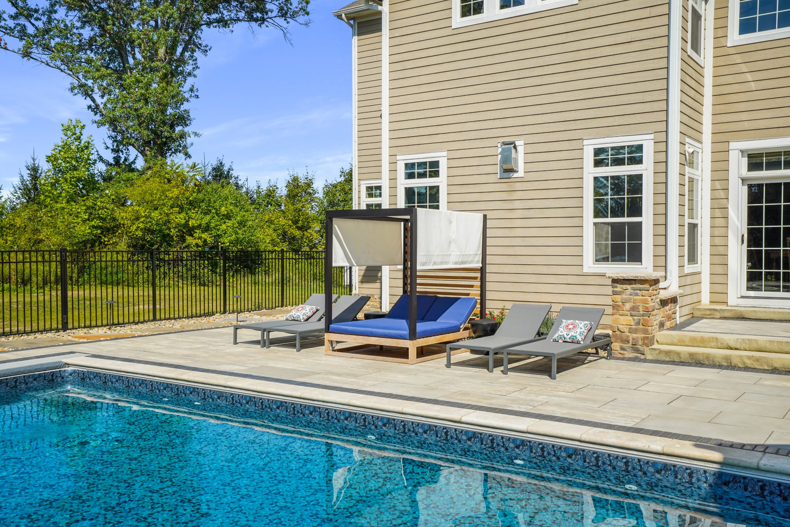 Pool chairs within fenced area and trees outside fenced area