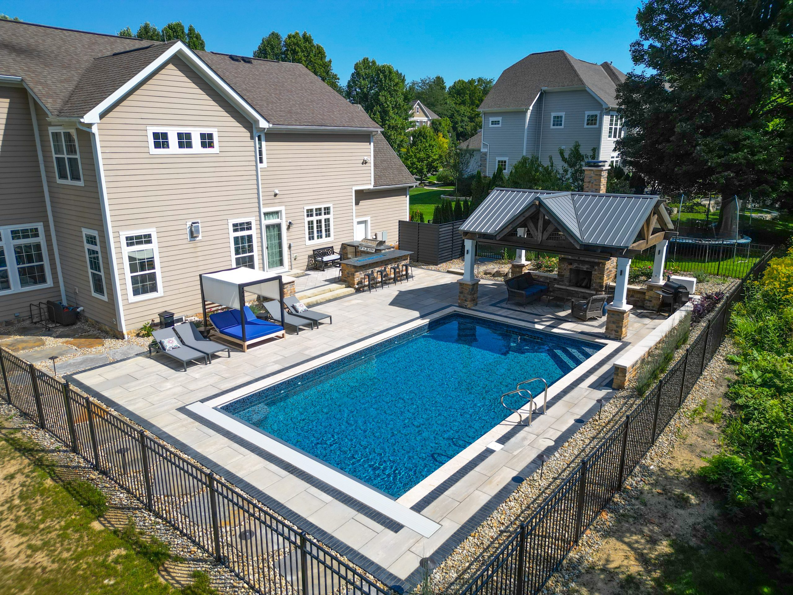 Pool in backyard surrounded by green trees