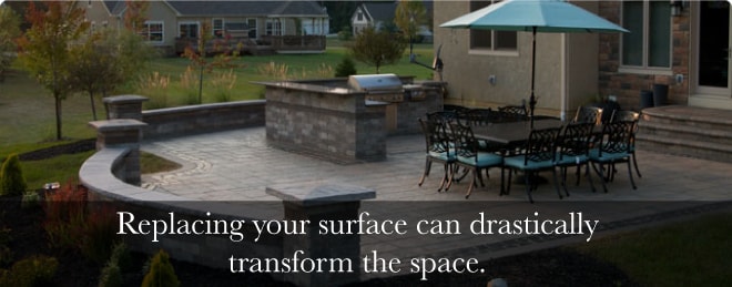 A big square-shaped backyard patio with a section for grilling and outdoor table and chairs to seat 10 people, with text below reading "Replacing your surface can drastically transform the space."