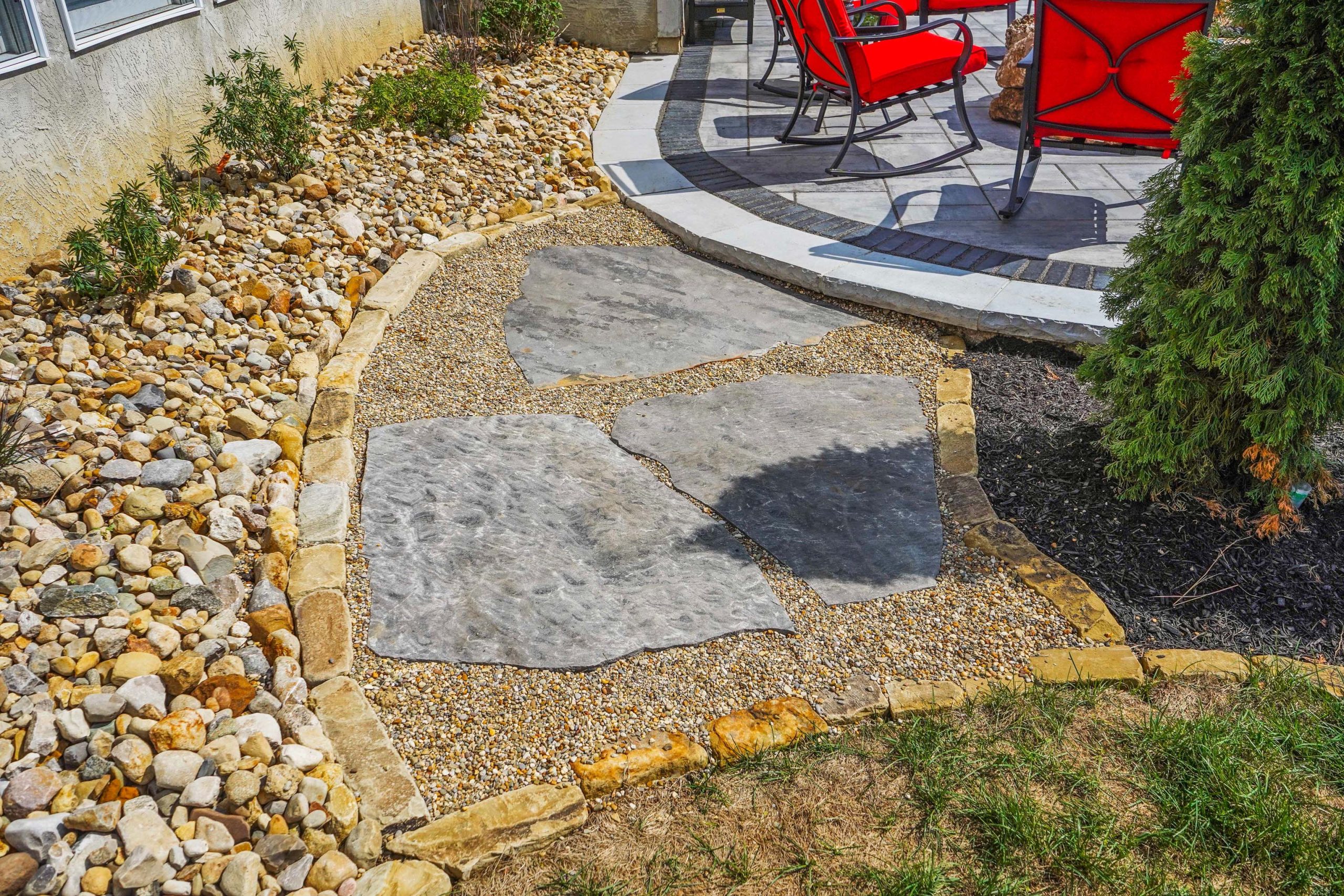 Walkway floor hardscape with red chairs and shrubs