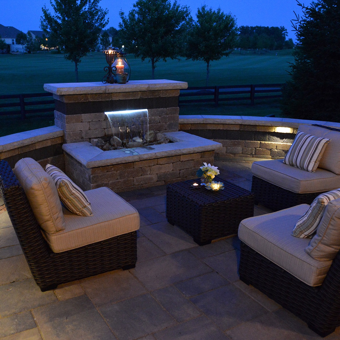 Water feature hardscape with comfy chairs and overlooking lawn.