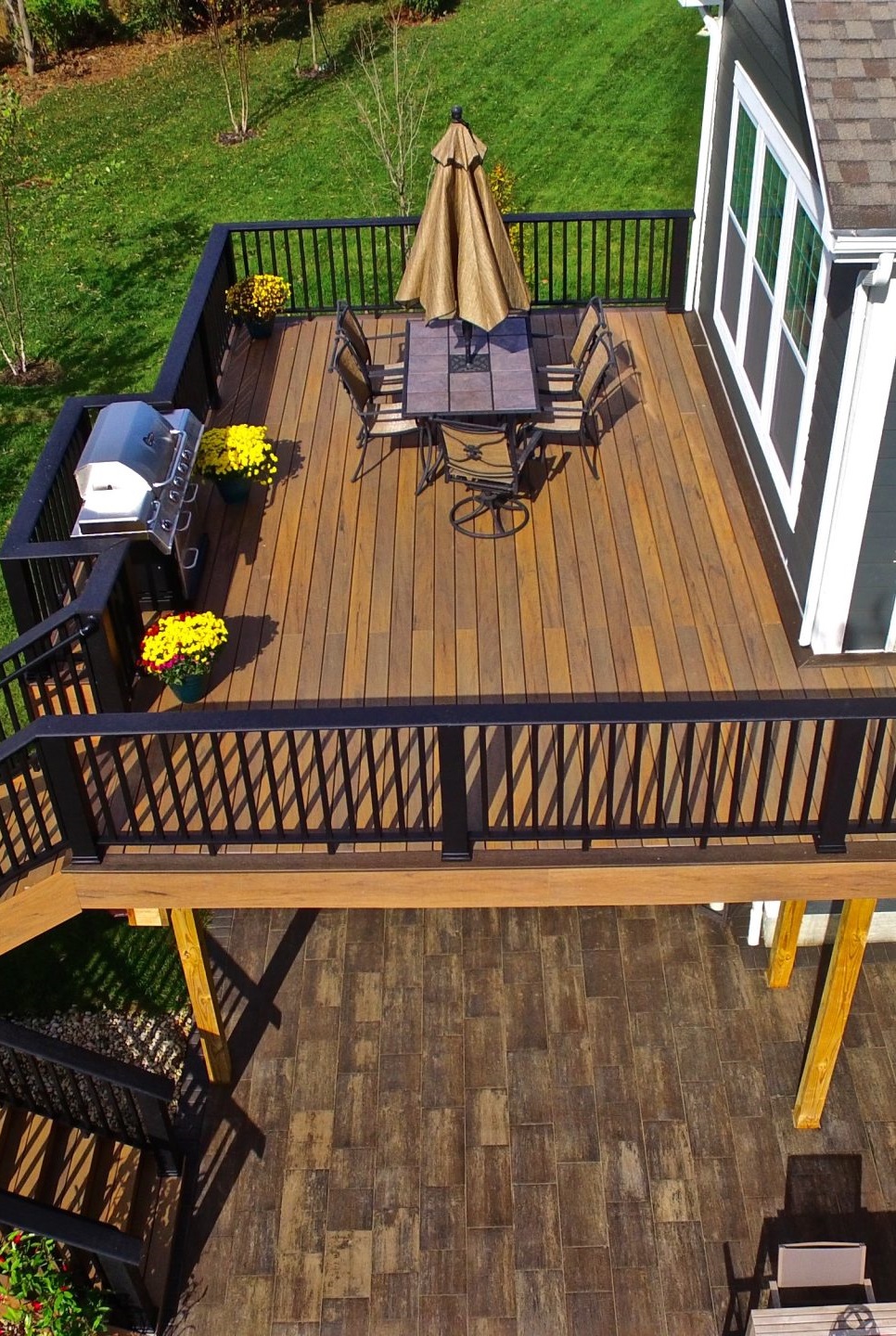 Upstairs deck with grill and dining setup overlooking lawn