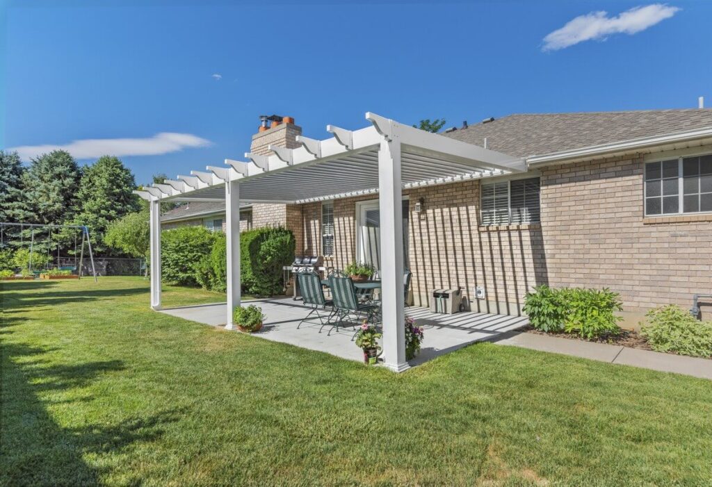 pergola jutting out from back of house over a patio with natural light